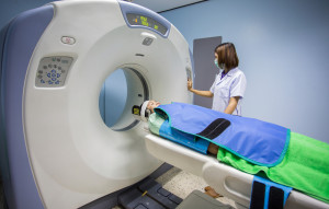 Radiologic technician mature female patient lying on a CT Scan bed
