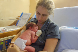 portrait of mother and newborn baby resting after childbirth in hospital room
