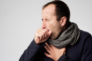 Mature man in scarf is ill from colds or pneumonia. Suffering from flu virus.