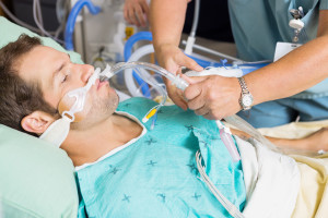 Nurse adjusting endotracheal tube in patient's mouth at hospital